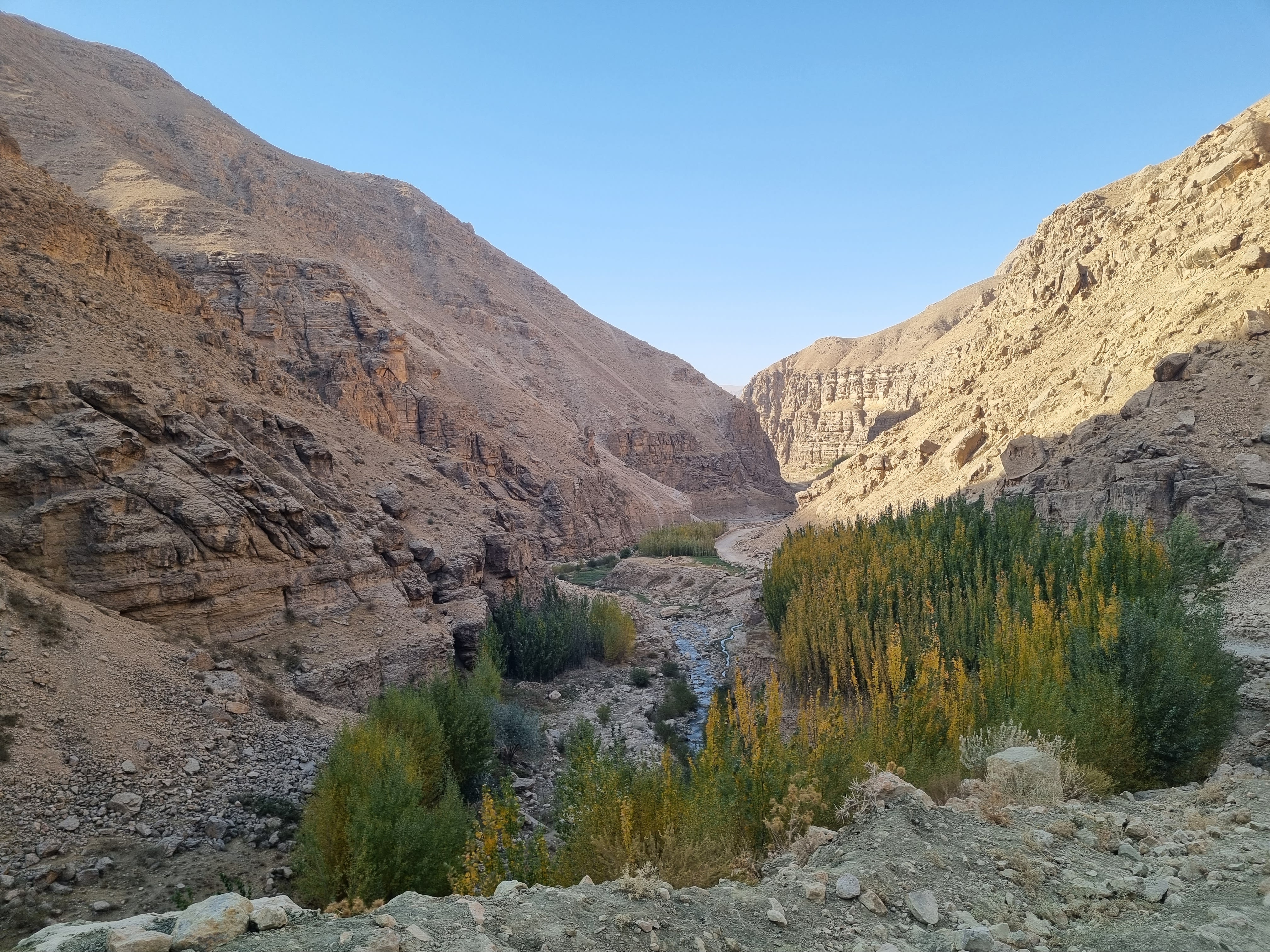 A green valley between two dry mountains.