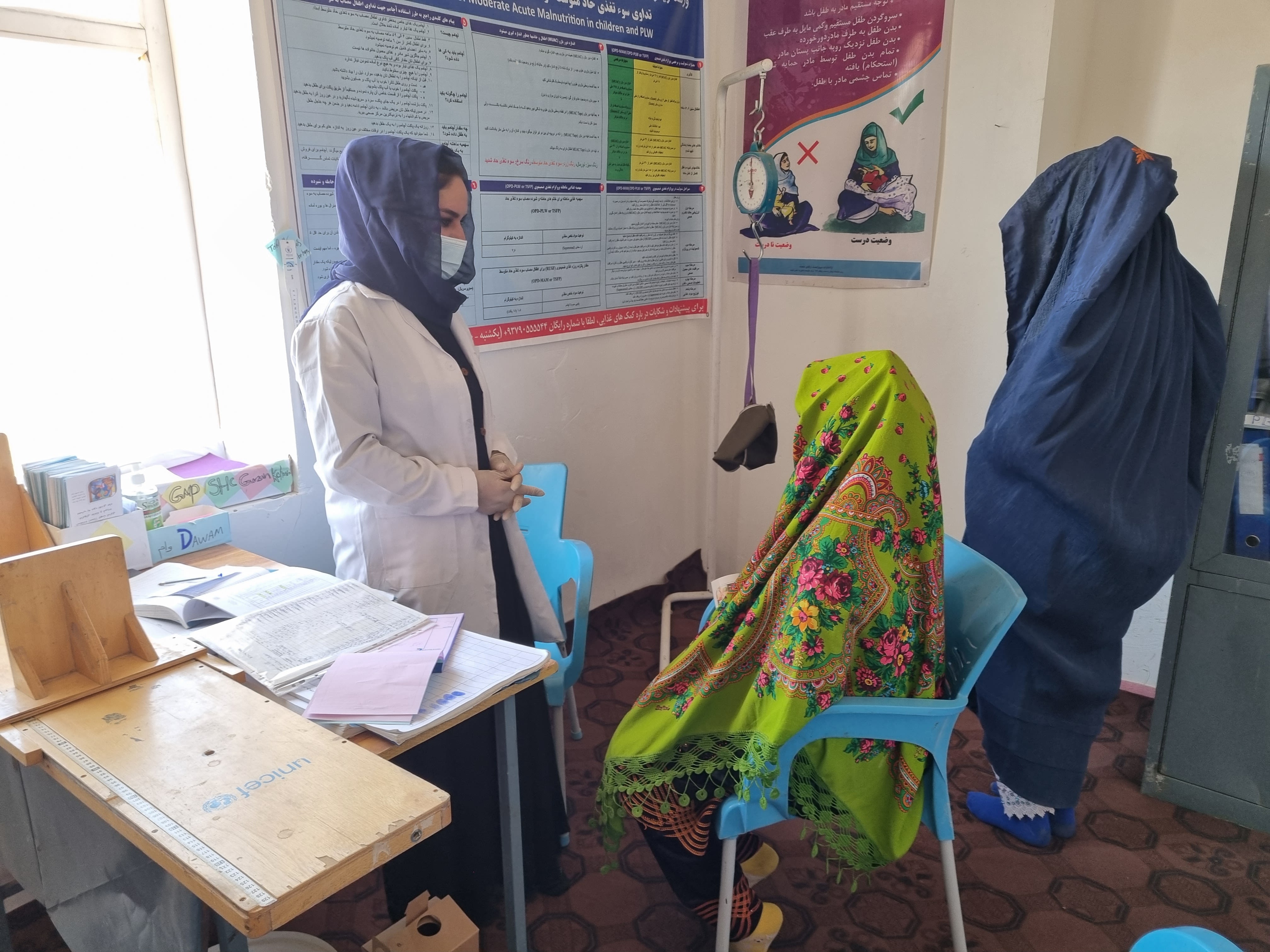 Two female patients receive advice from a female healthcare professional.