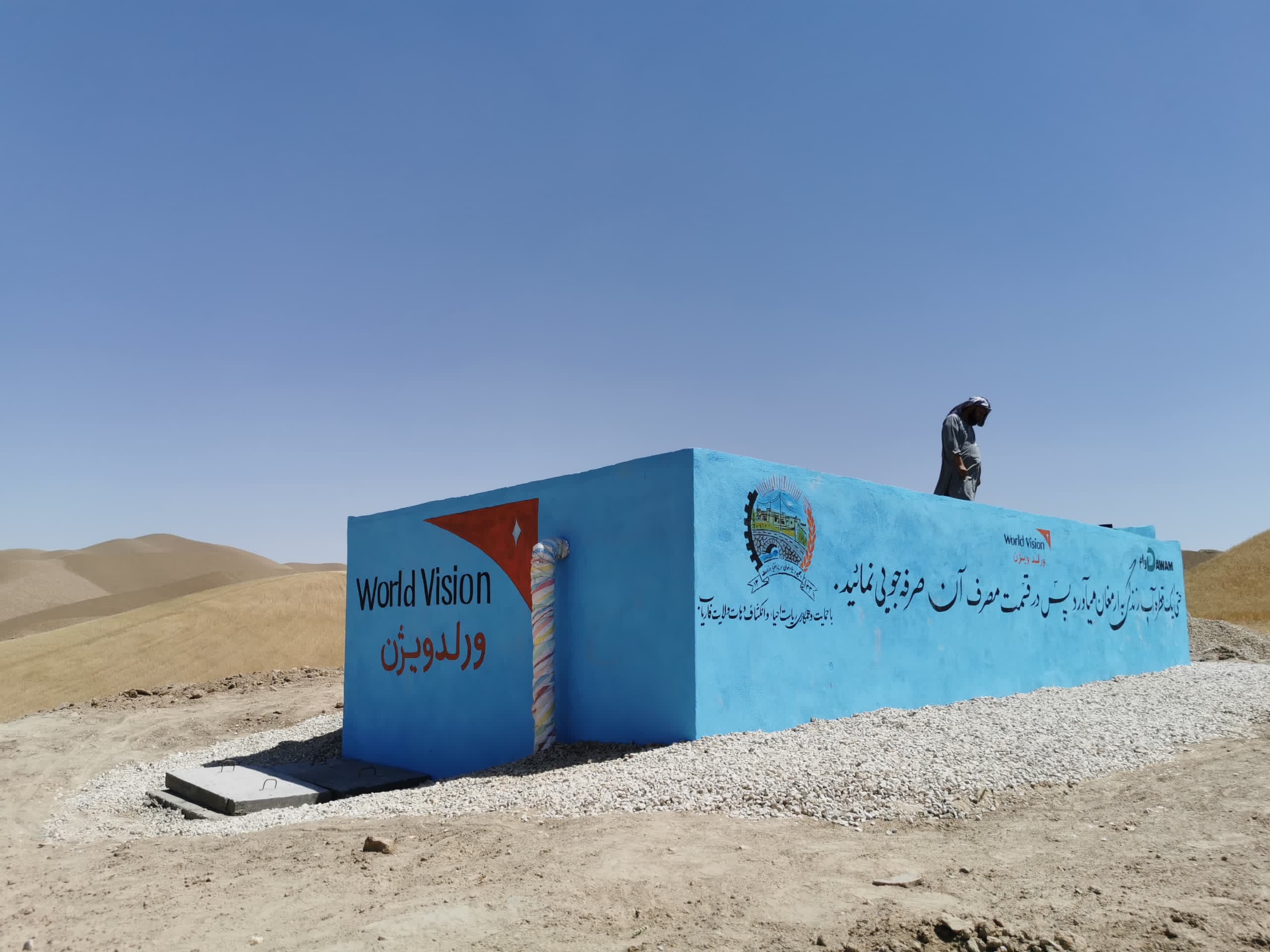 A blue water reservoir in dry, hilly terrain.