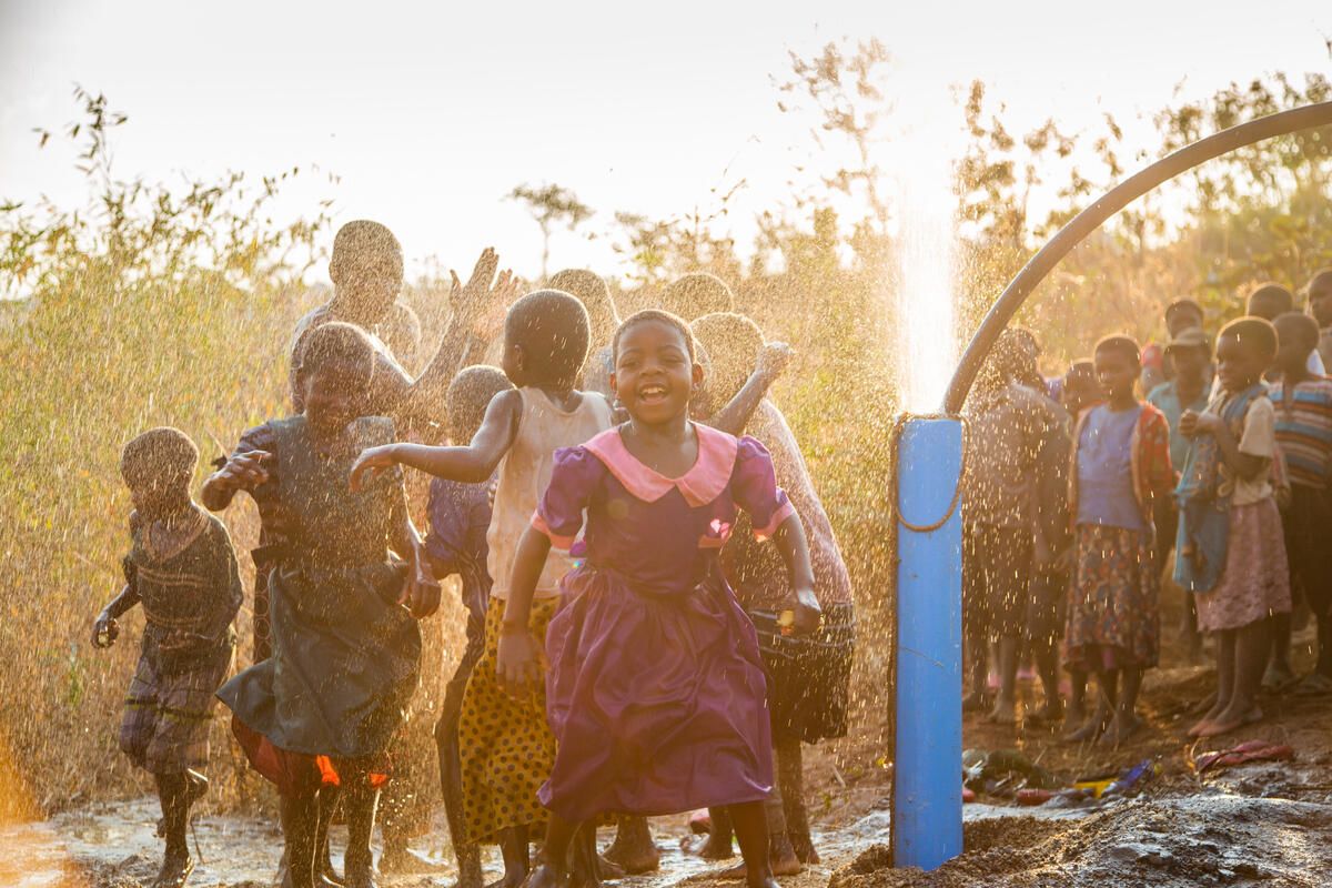 Children rejoice when clean water comes up from newly-drilled well in Malawi