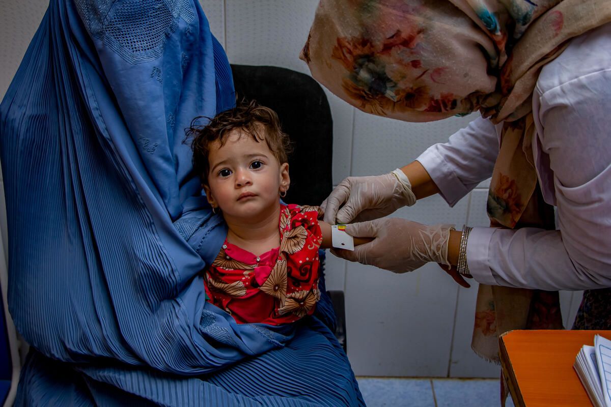 World Vision health staff in Afghanistan measure the circumfrance of a toddler's arm to check their nutritional condition