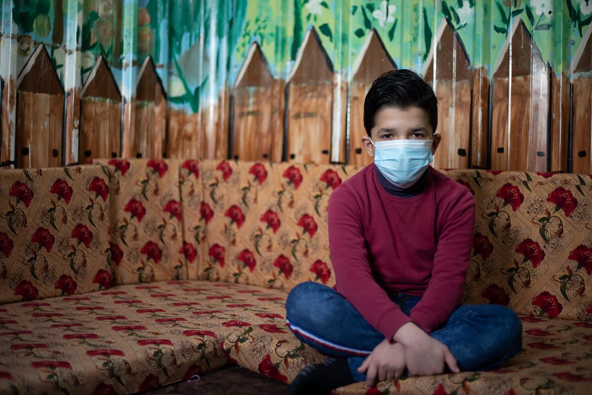Hamza a Syrian refugee child sits at his home in Jordan