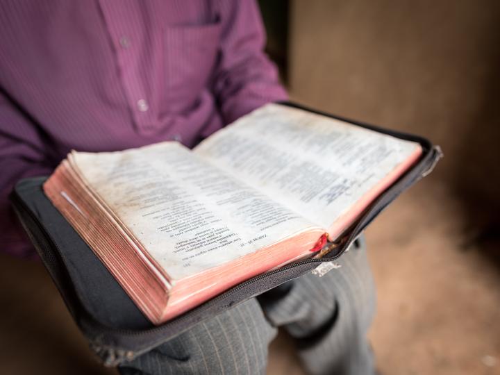 A pastor holds his bible at his church