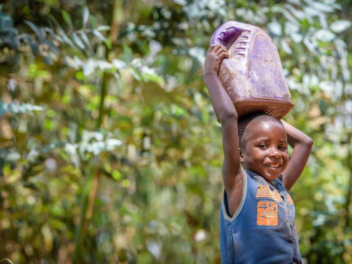 Rwandan girl carries water home