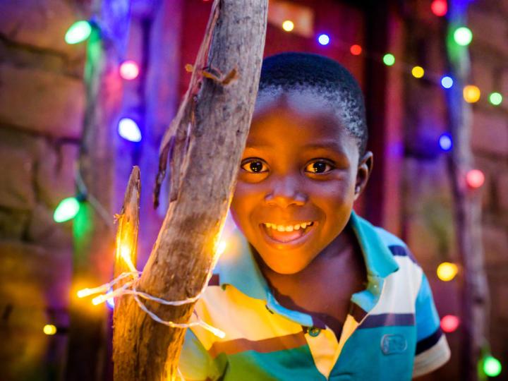Child in Africa with Christmas lights