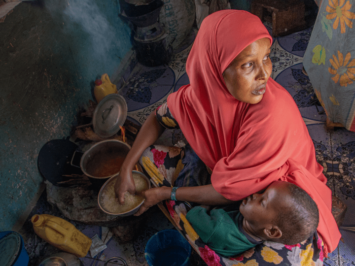 Mother cooking for malnourished child