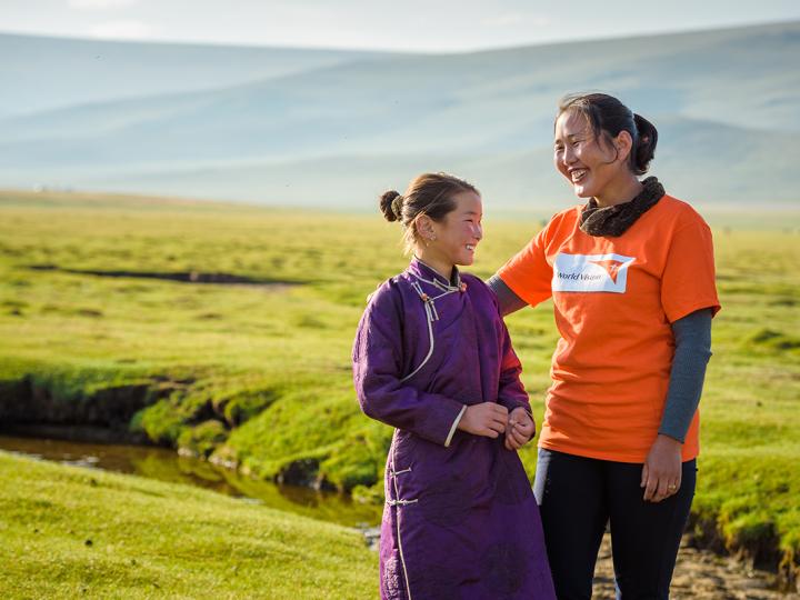 World Vision staff walks with child in Mongolia