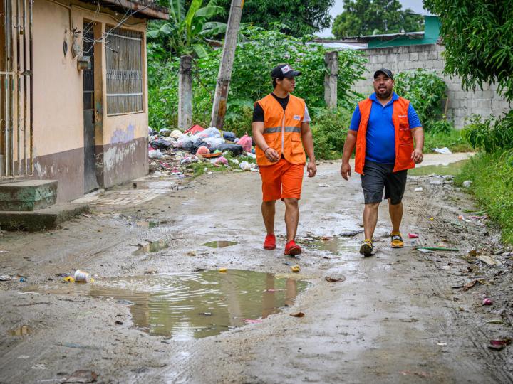 World Vision staff walk down a muddy road