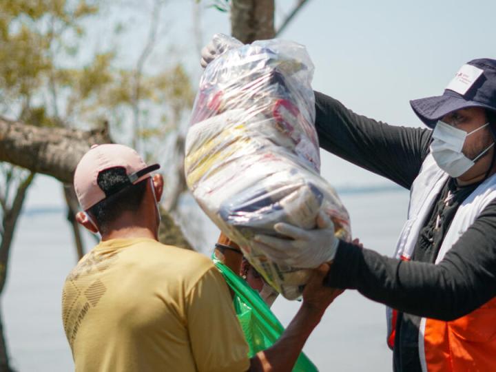 WVI staff hands bag of food to villager