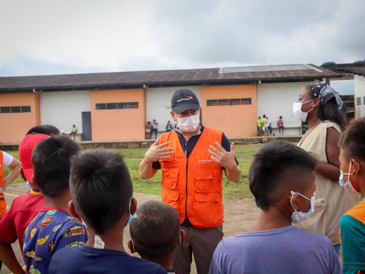 World Vision staff speaks to children