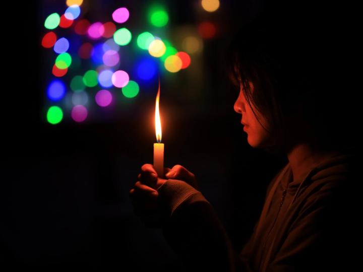 Child holding candle in the dark