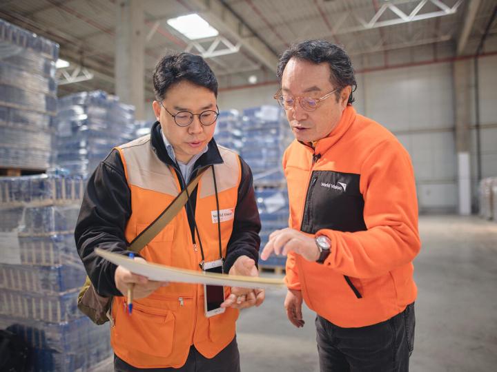 two WVI staff stand in a warehouse talking
