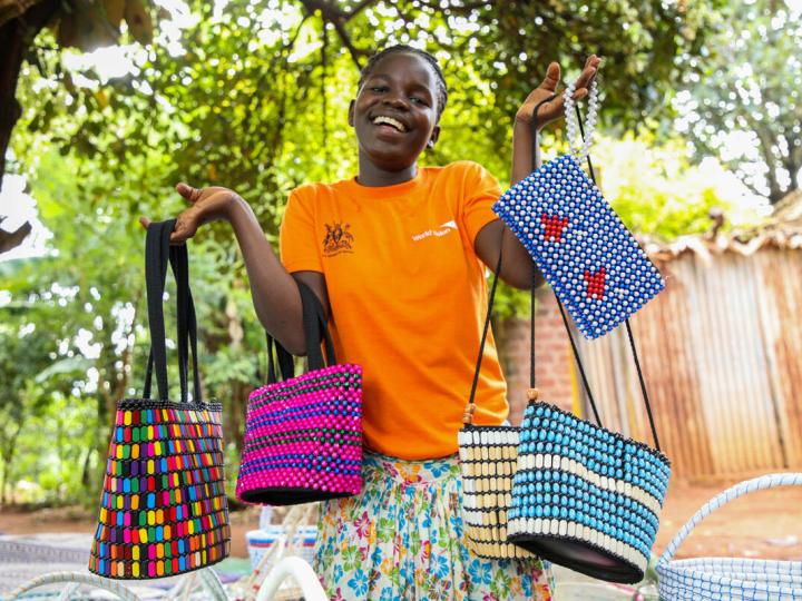 Young girl in orange shirt shows colorful bags