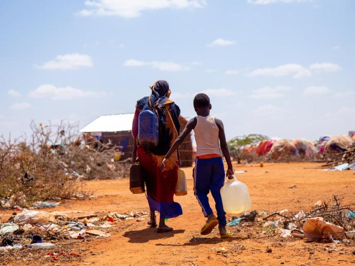 Two people carrying their belongings in the drought-ridden portions of Somalia
