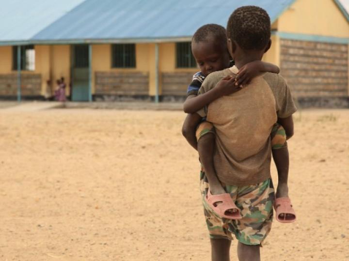 Young boy carries his brother