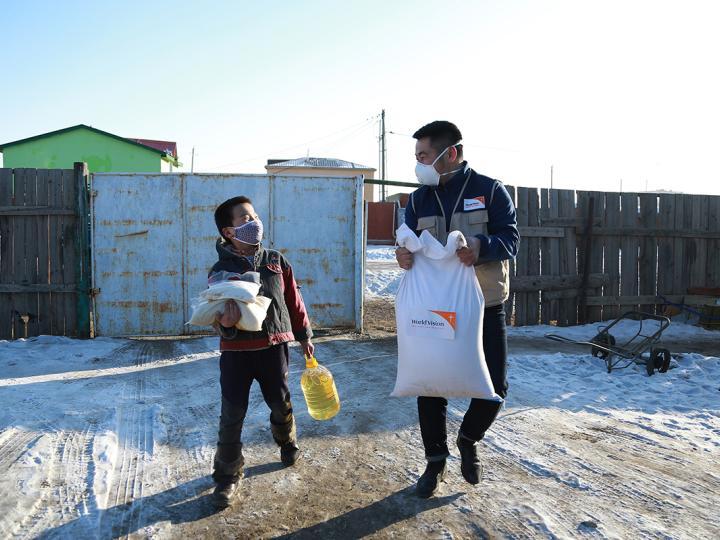 World Vision staff in Mongolia walks with child