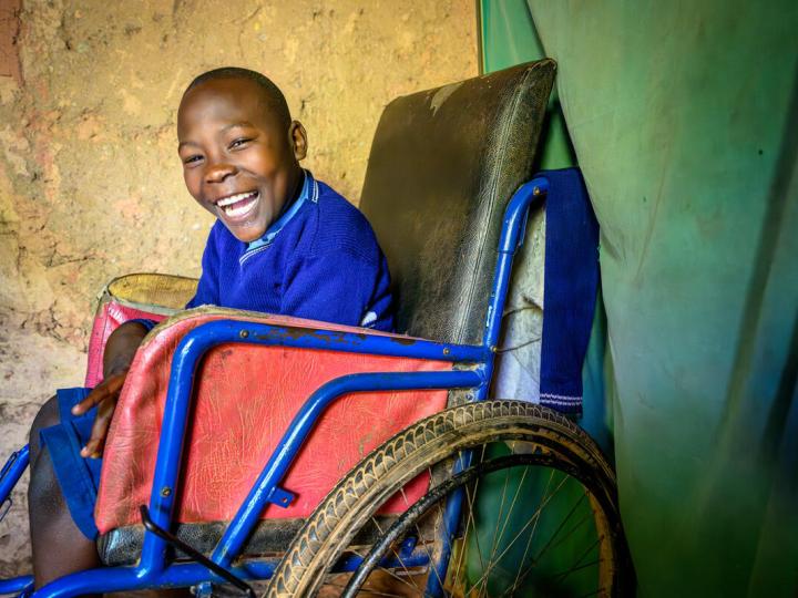 Abraham smiling as he its in his wheelchair