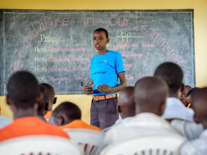 Children listen to John Bosco Mugagga, a World Vision Child Protection and Advocacy Officer, during a Child Parliament meeting at a school in Nakasongola, Uganda