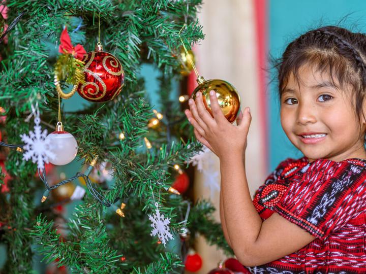 Hanny, 5, sponsored, loves the Christmas tree and ornaments at her home in Choxacal, in the San Bartolo Aguas Caliente area program, Guatemala.