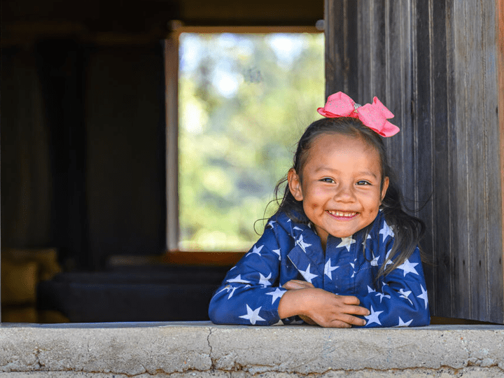 Lusi, 5 year-old looks through a window in Buena Vista, Honduras.