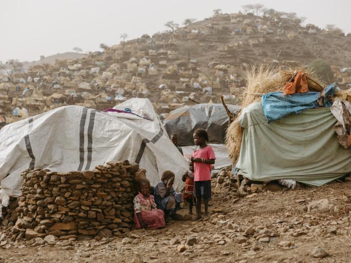 Children sitting next to their tent