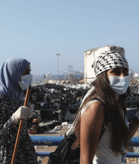 two women stand with a city skyline behind them