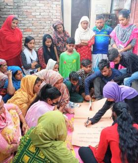 a group sitting in a circle having a meeting