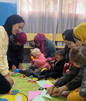 Group of Mothers supported by a volunteer on early childhood development