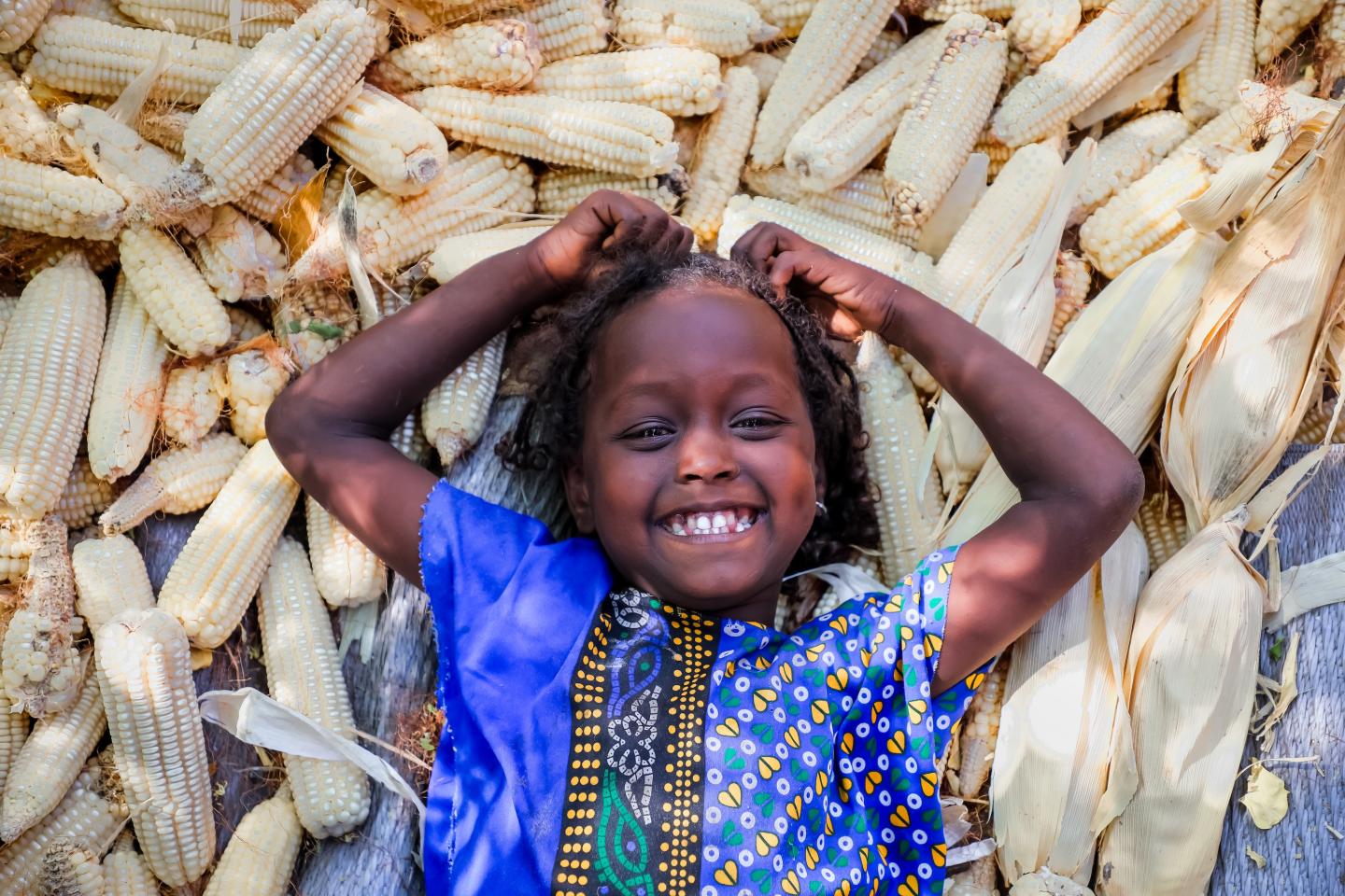 Tamiro smiling in laying in corn 
