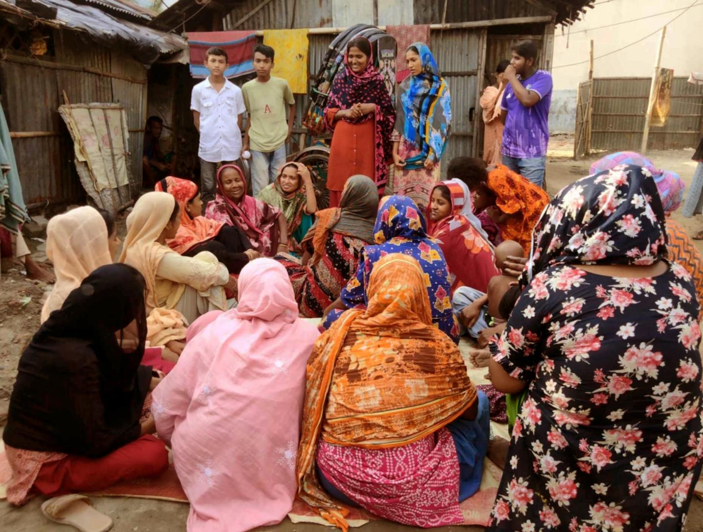 Taslima leading a community discussion with women and children in Chittagong to prevent child marriage and support out-of-school education.