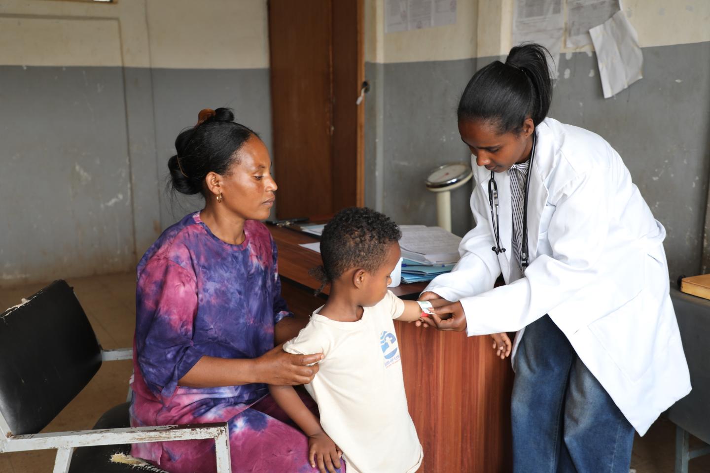 Tarike examining a child