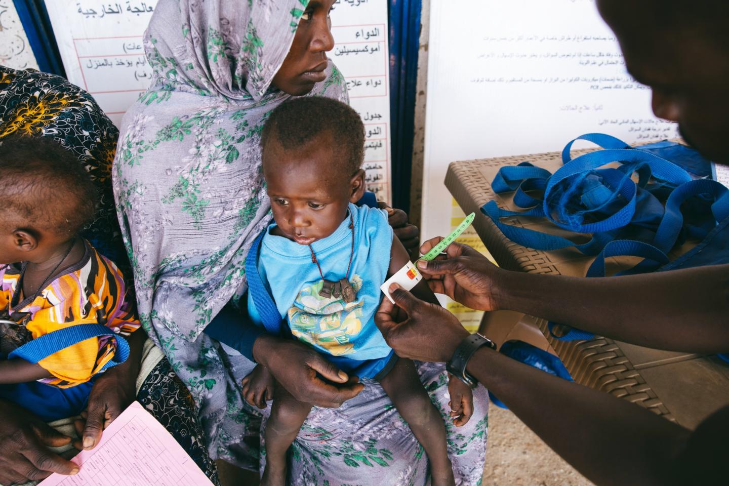 At El Ferduouse Clinic in South Darfur, health staff measure a young child’s arm to understand the level of malnutrition and provide the right care.
