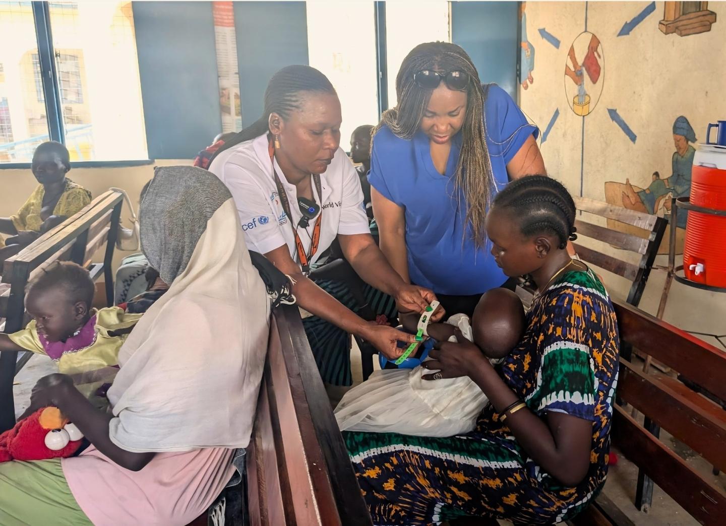 Fola Komolafe, World Vision UK CEO, visits a World Vision-supported health clinic, where Rukheya receives care for her child. 
