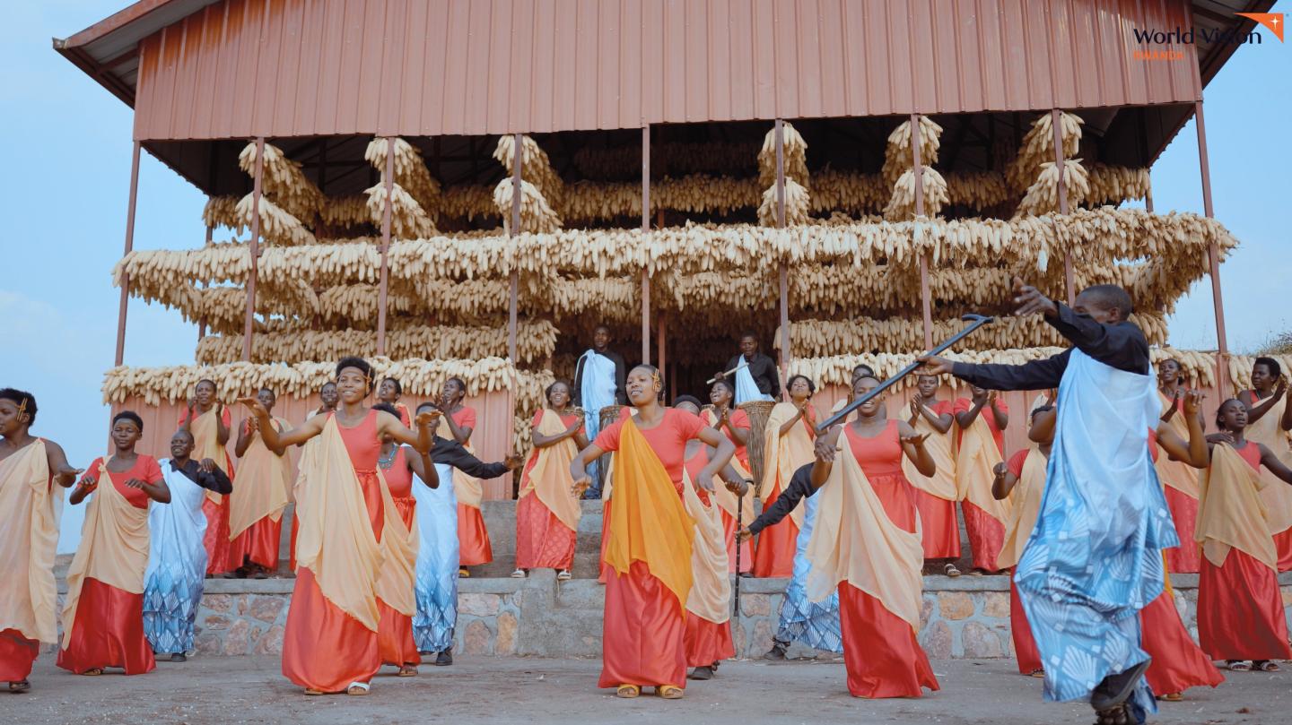 ‘Inyamamare’ Troupe supported by World Vision, behind them is the maize drying shade were they keep their maize