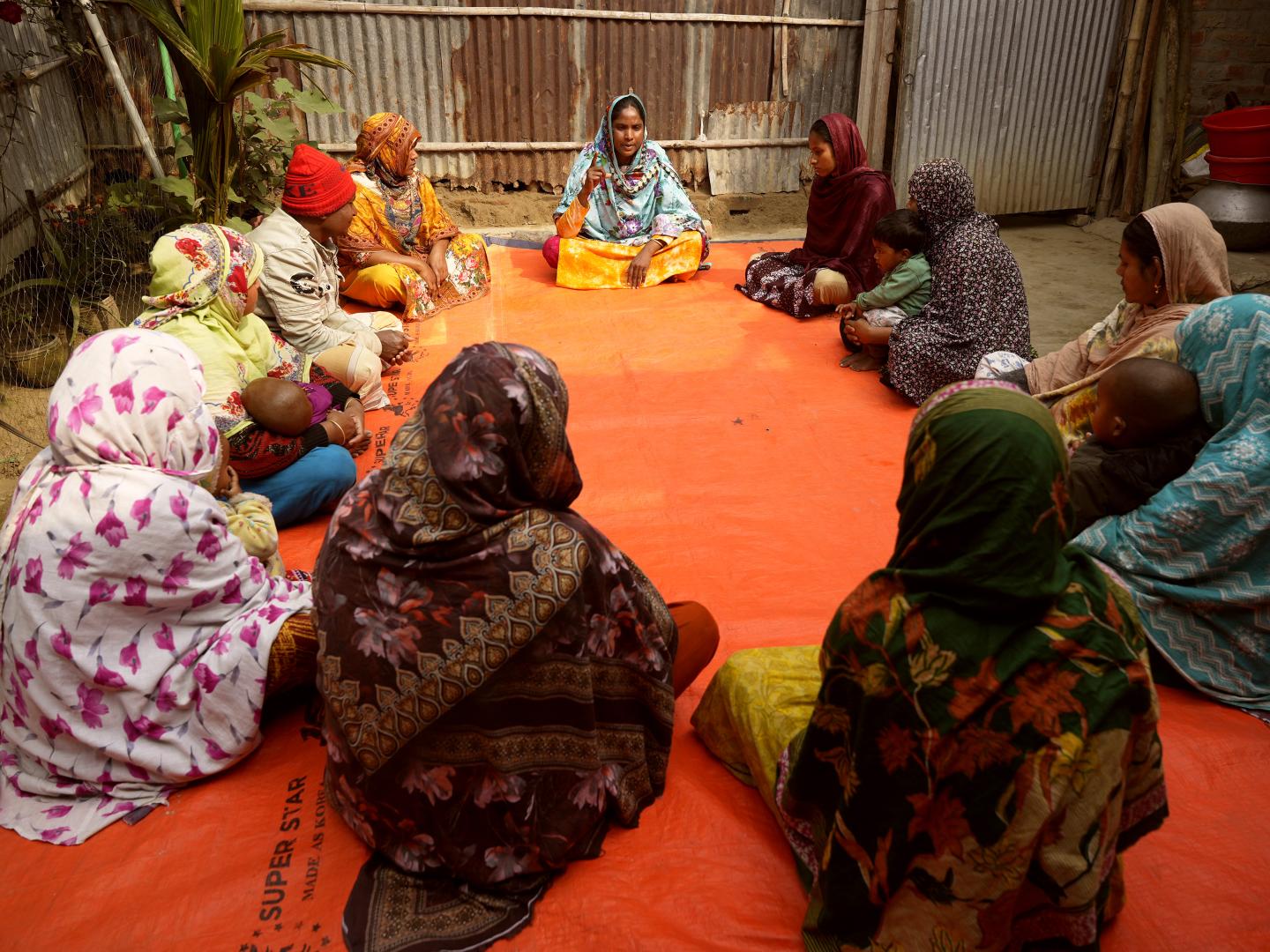 Sufia leading a community discussion with local women and children to address child marriage and school dropouts.