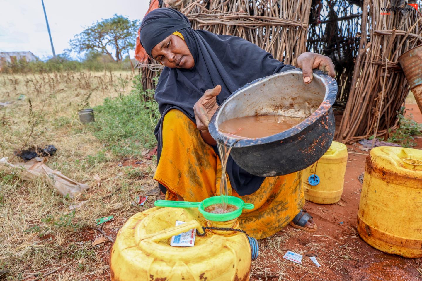 Habiba demonstrates how she strains water collected from the pan to remove visible dirt and debris. While the process helps clear sediment, the water remains unsafe for drinking without proper treatment. ©World Vision Photo/Mirriam Kioko