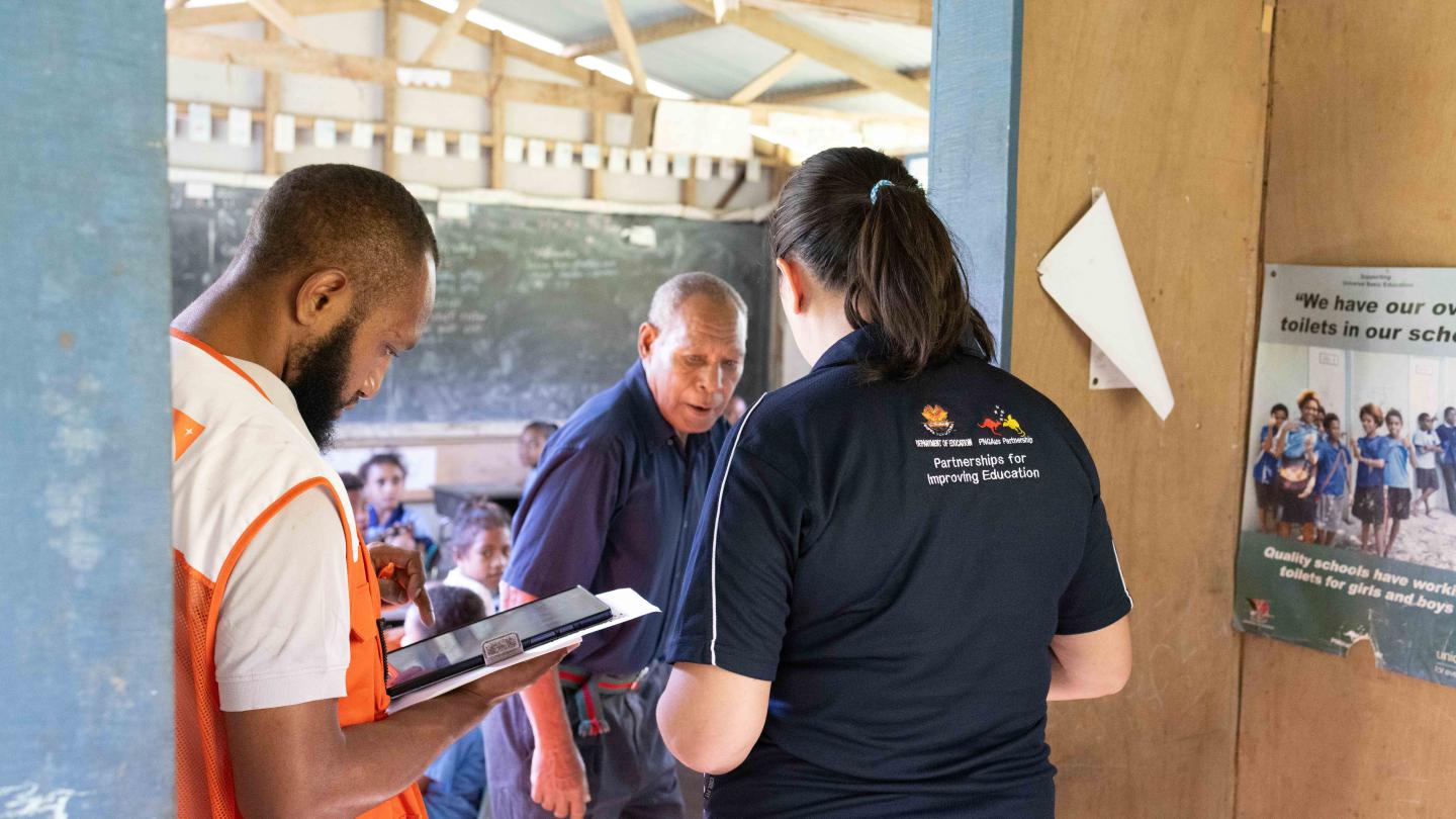 Members of the PIE team assessing classroom lessons during a visit to a remote Rigo community school