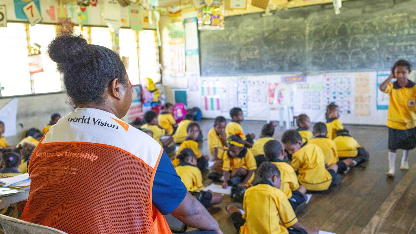 World Vision officer observing and assessing a classroom lesson under the PIE Project