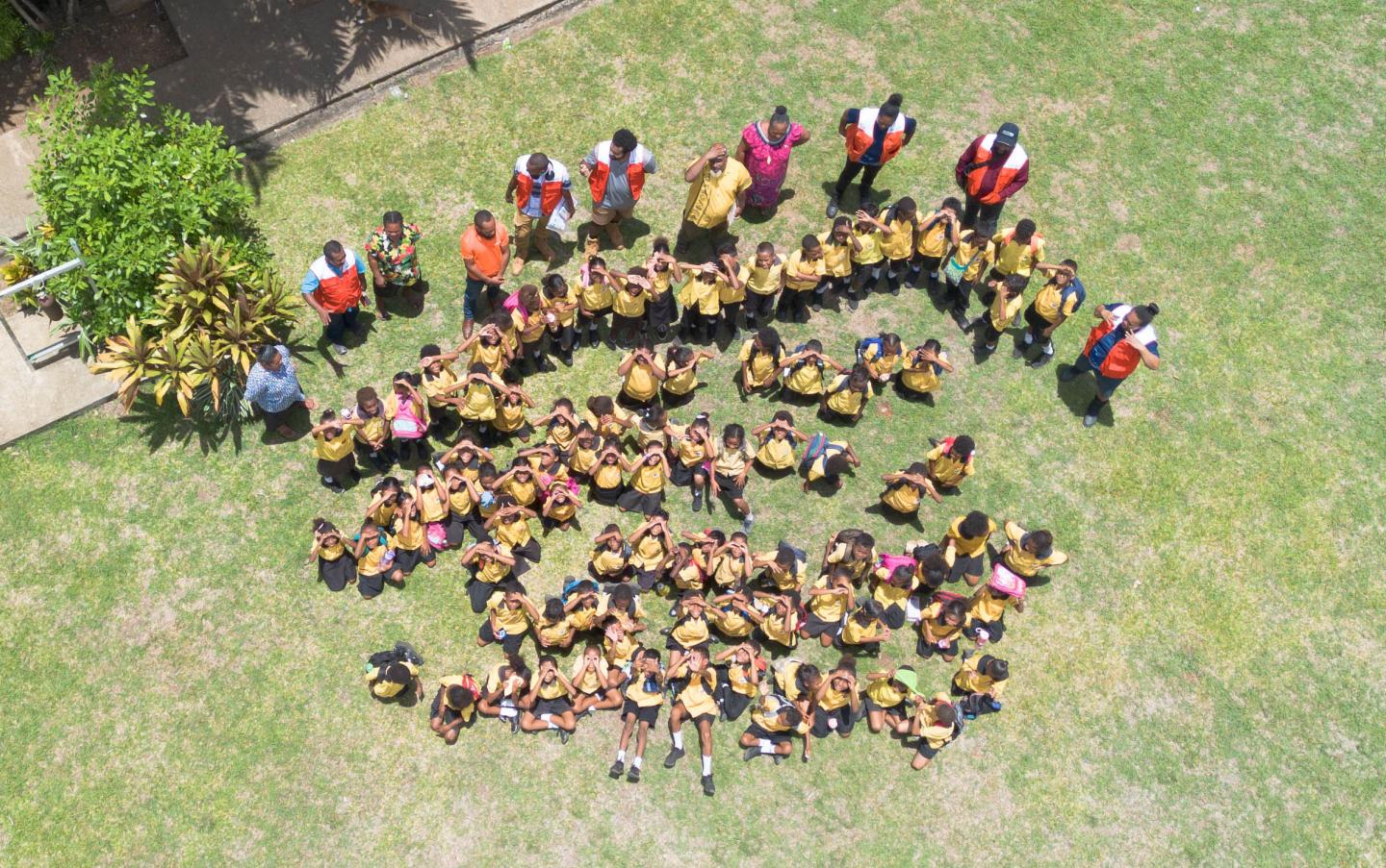 The students and teachers of Kupiano Elementary School with the PIE Team posing for a group photo