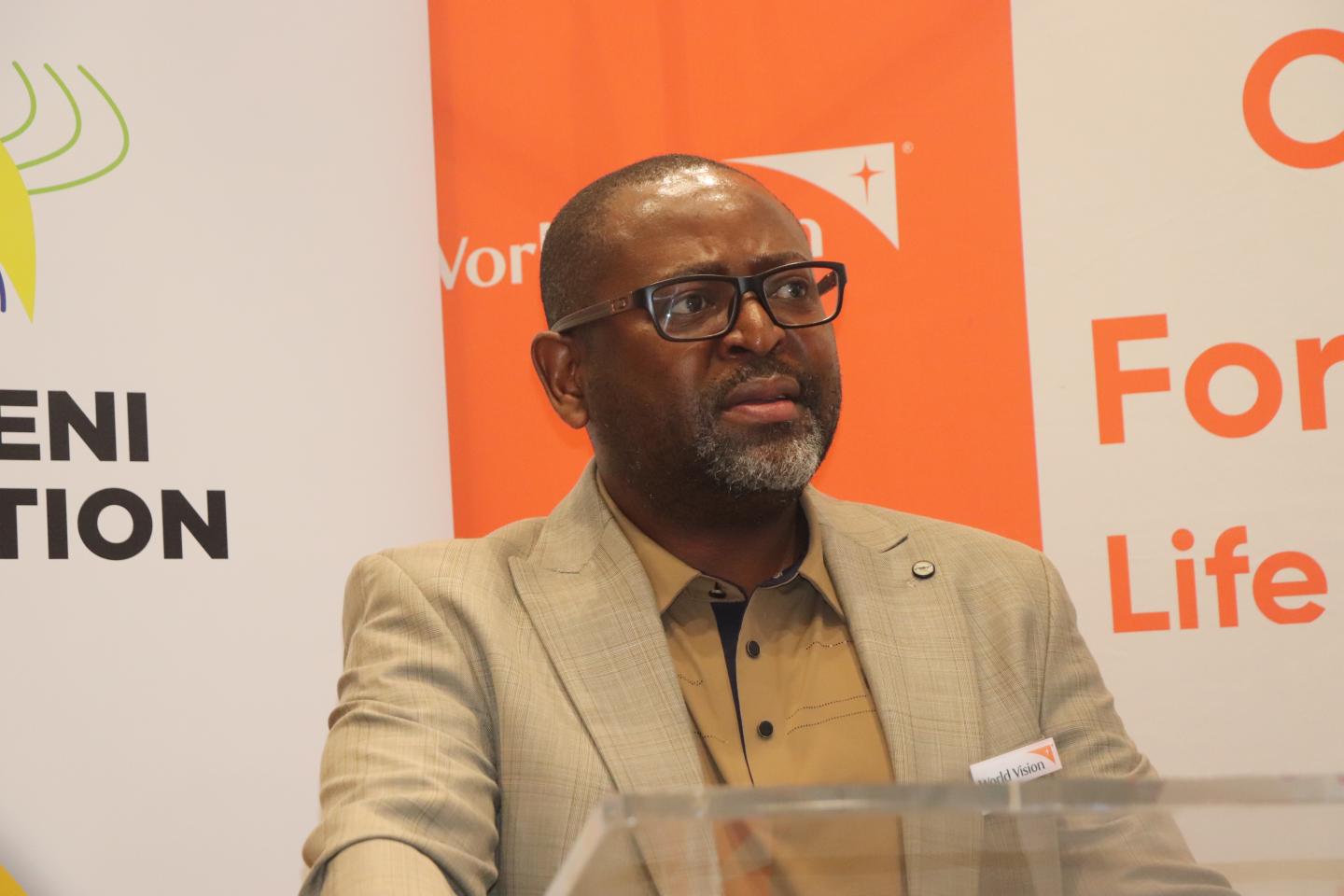 A man standing behind a podium speaking.