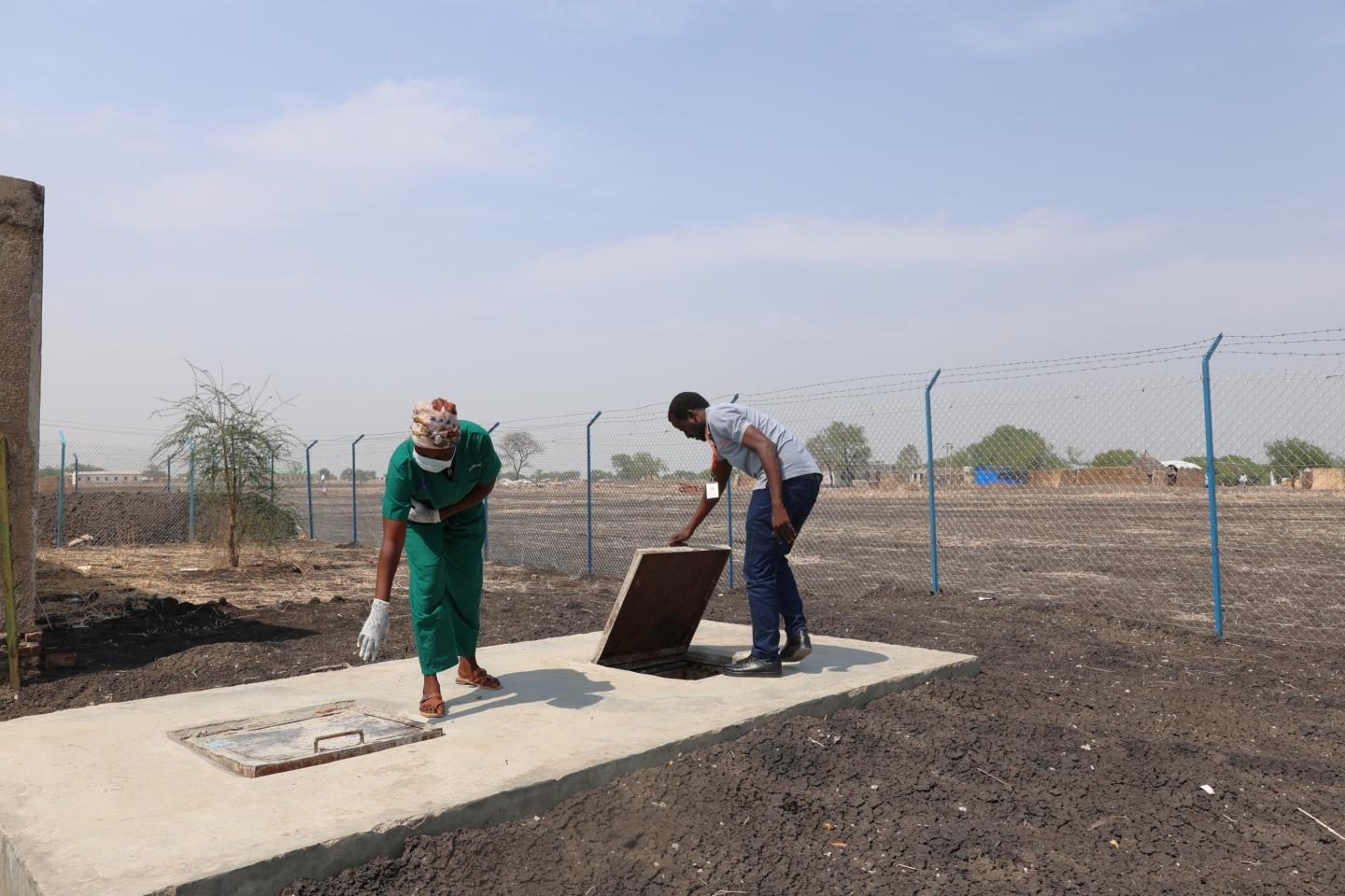 Rebecca showing World Vision's Staff Matrin the newly constructed Placenta pit