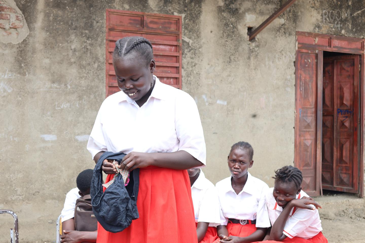 Nyayiik demonstrating proper use of the sanitary towel