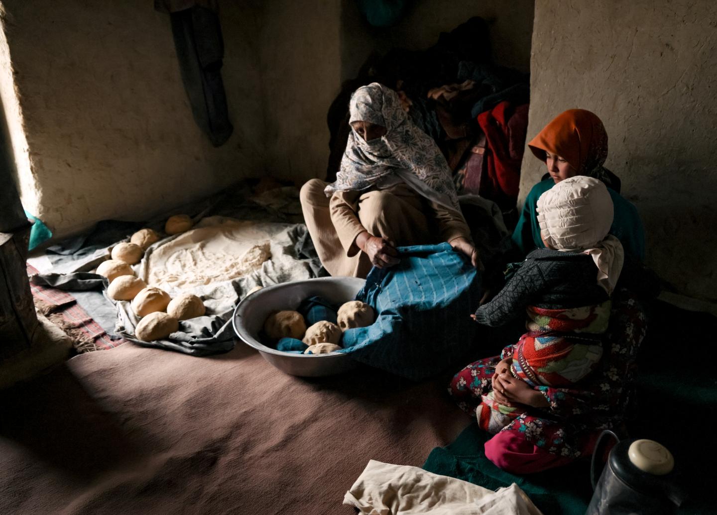 Kemia prepares bread for her orphaned nephews, doing what she can each day to keep them fed/ Afghanistan / 2025.