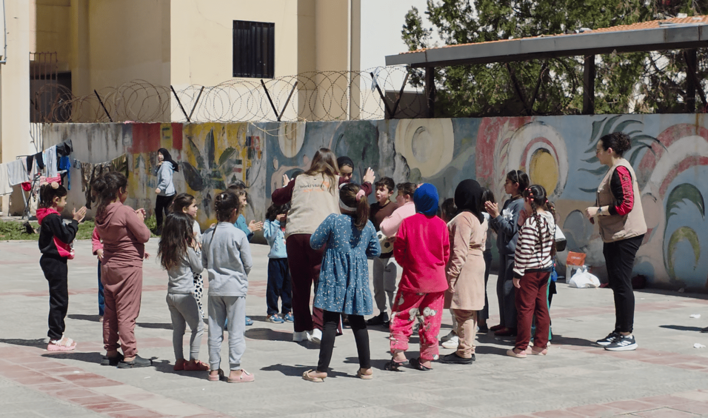 A group of children stand in a circle playing
