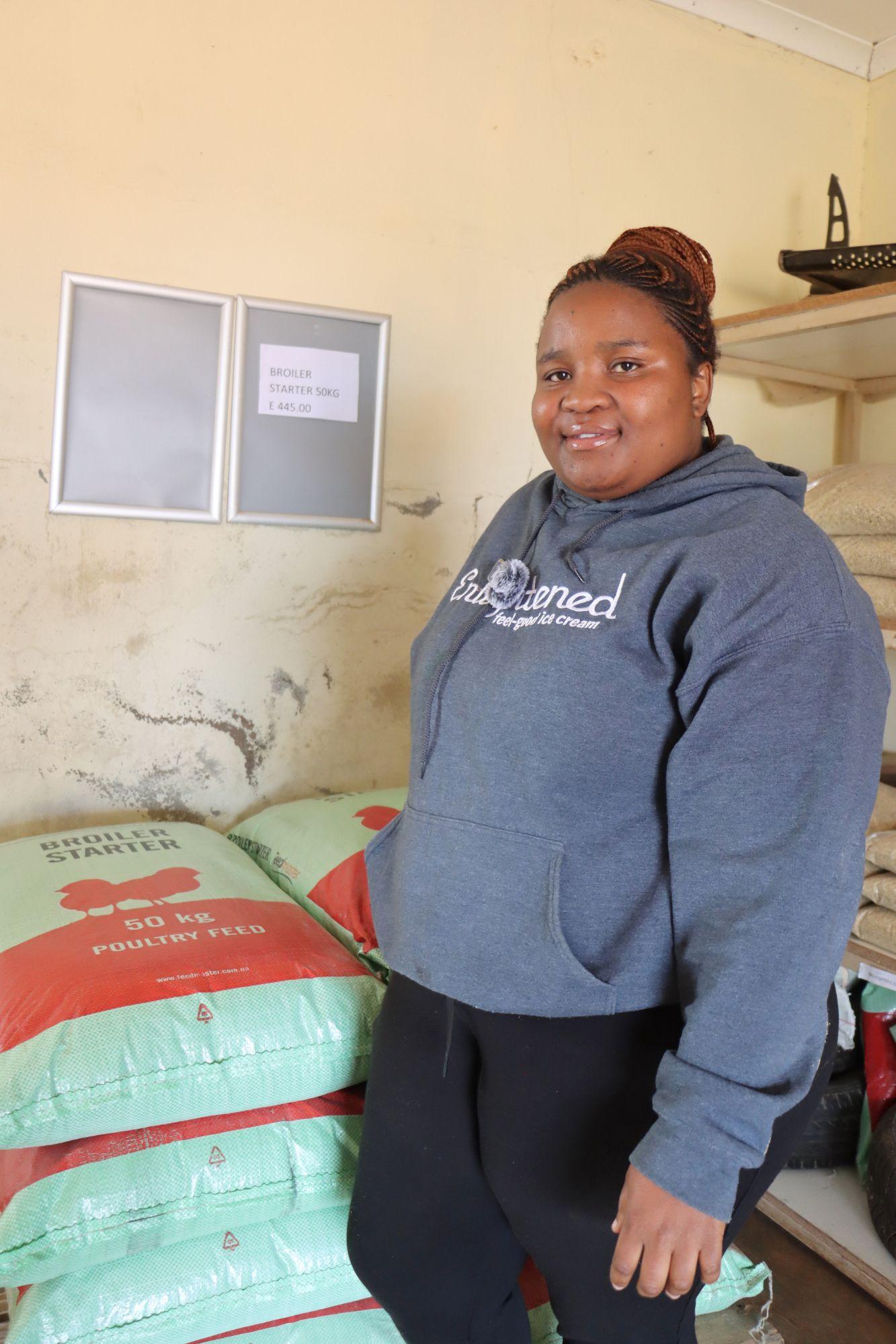 A woman standing next to animal feed.