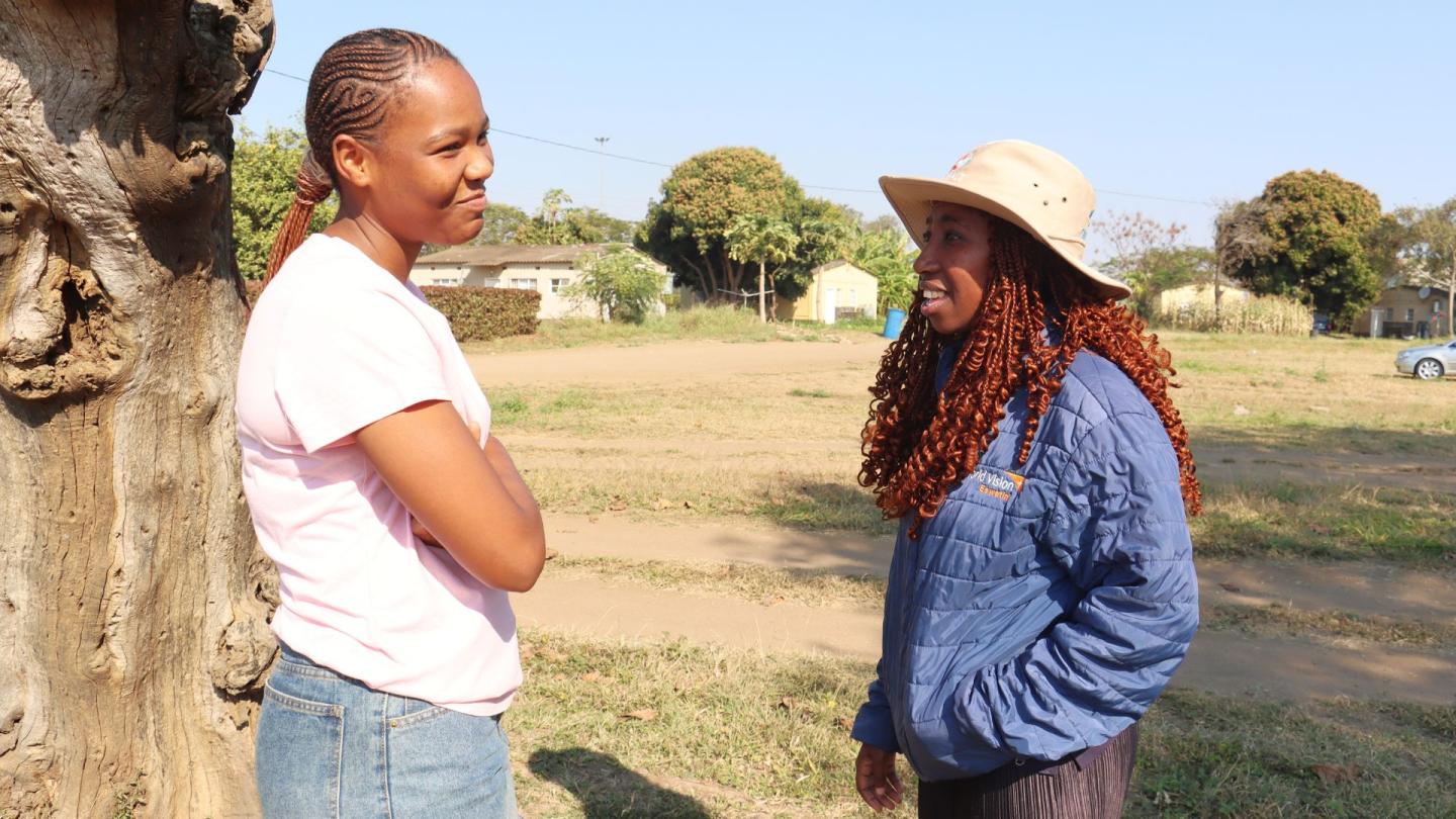 Two people standing and speaking.