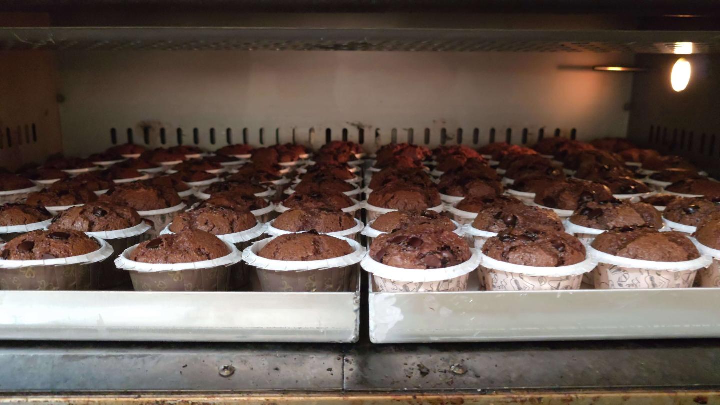 Freshly baked chocolate muffins cooling at a local bakery.