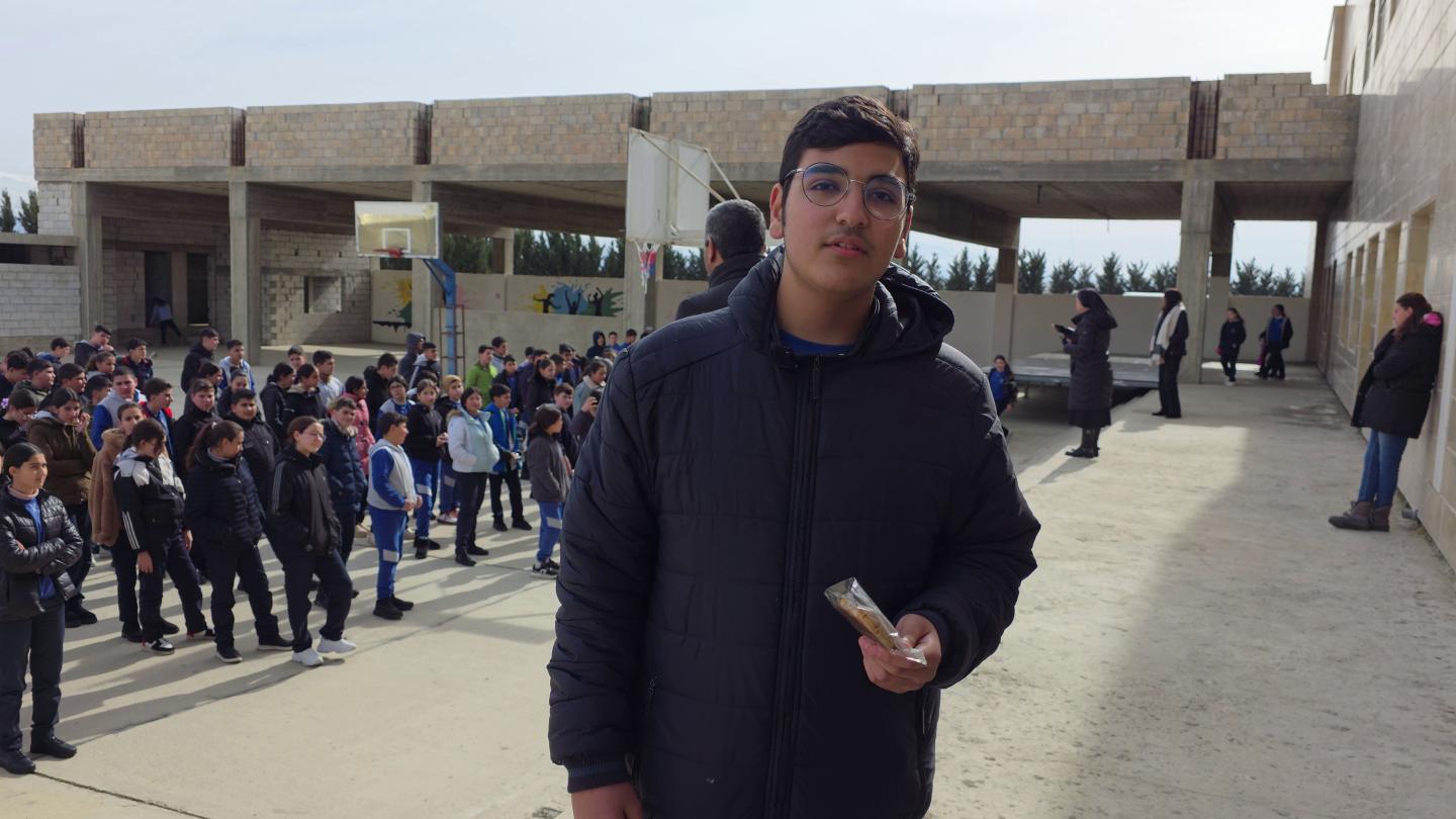 Anthony, a Grade 9 student, holds one of the healthy snacks provided through World Vision's School Feeding Project.