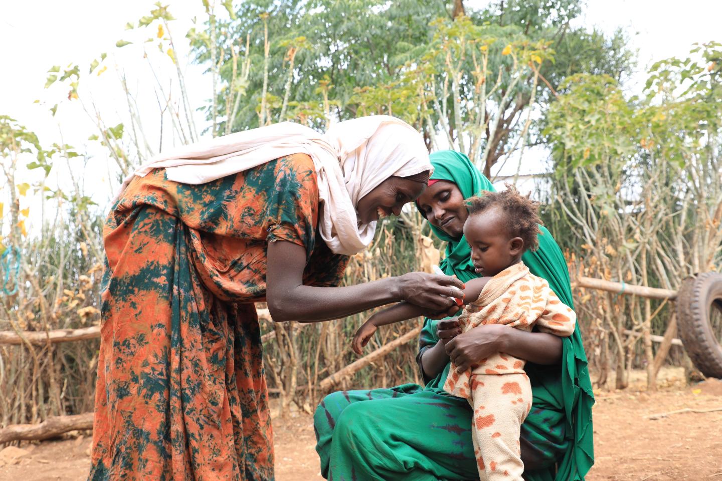 Kamila screening her neighbors child using MUAC after training