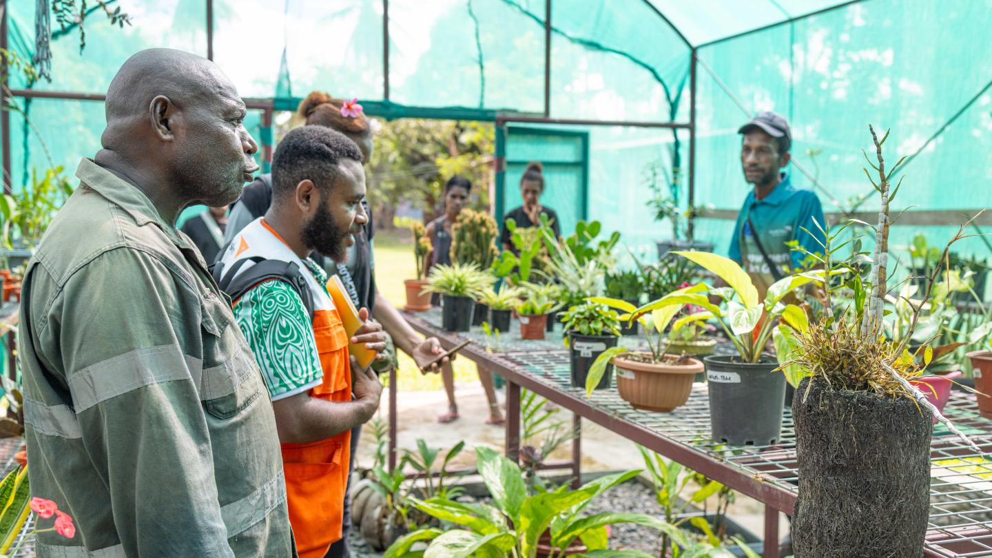 William showcasing flower products at the main community nursery to World Vision staff